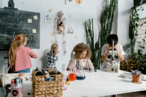 Young children actively learning in the classroom as they happily build do chemistry experiment in the class